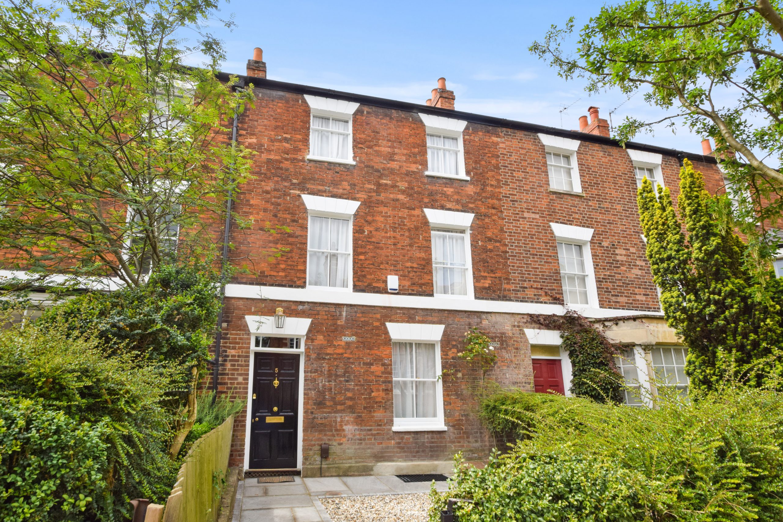 Victorian brick townhouse with greenery